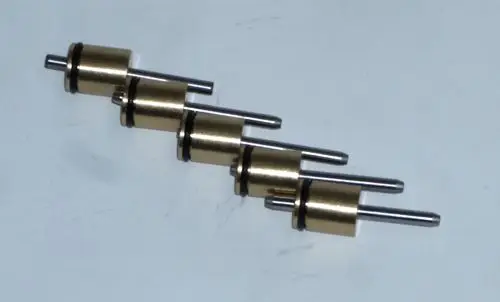 Daikin-Komponenten in zylindrischer Form mit metallischen und gummiartigen Elementen, die in einem strukturierten Layout angeordnet sind.